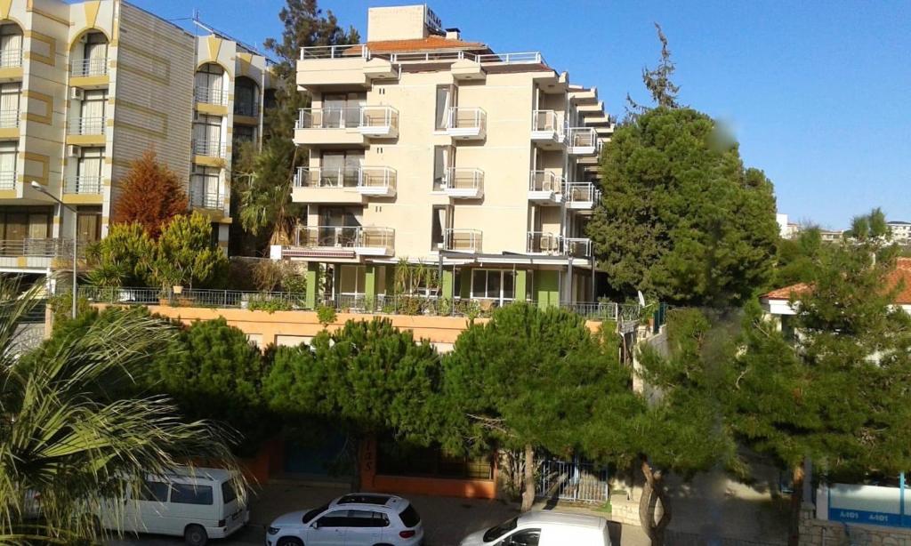 een groot appartementencomplex met auto's voor het gebouw bij Atlas Cesme Apartments in Çeşme