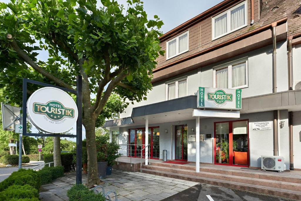 a hotel with a sign in front of a building at Hotel Touristik in Neuenburg am Rhein