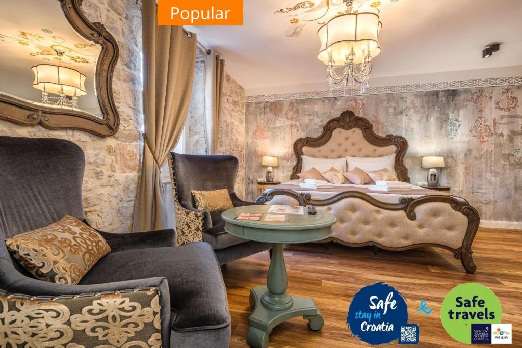 1 dormitorio con 1 cama, mesa y sillas en Plaza Marchi Old Town - MAG Quaint & Elegant Boutique Hotels en Split