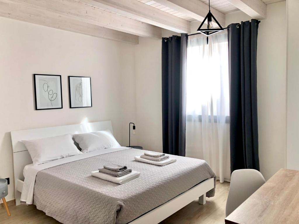 a white bedroom with a large bed and a window at Le Quattro Porte in Marsala