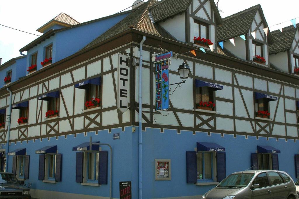 a building with a clock on the front of it at Hôtel Restaurant Aux Deux Roses in Neuf-Brisach