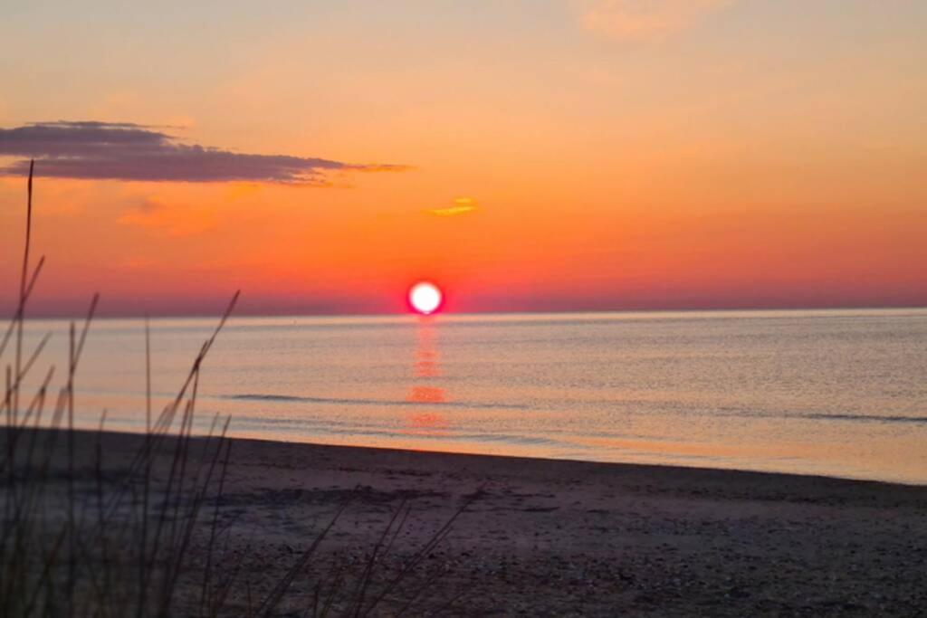 - un coucher de soleil sur la plage et un coucher de soleil sur l'océan dans l'établissement Super appartement les pieds dans l eau, au Cap d'Agde