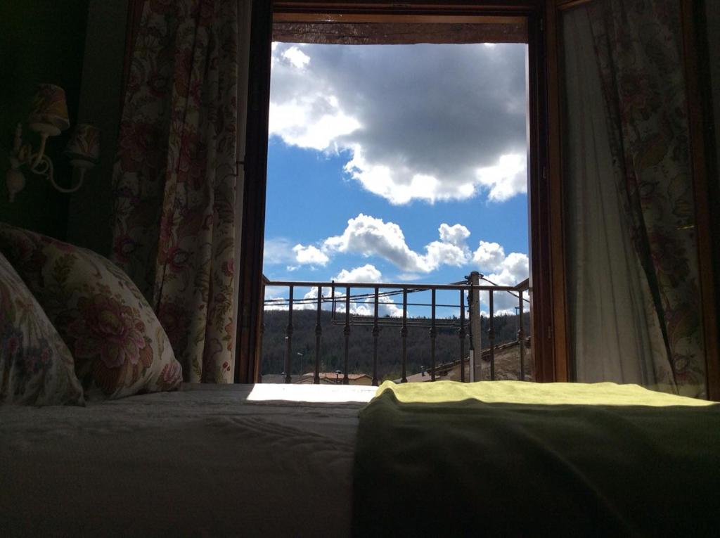 a bedroom with a bed and a window with a view at Hotel Rural Los Roturos in Maestu