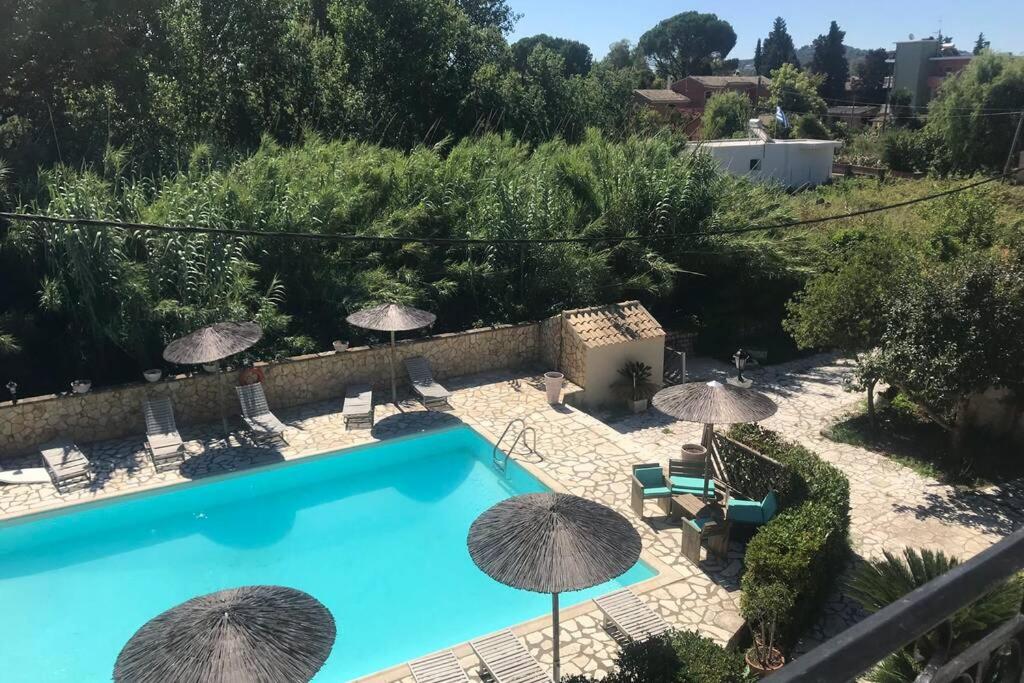 a swimming pool with umbrellas and chairs and a pool at Charieta n.8 in Áno Korakiána