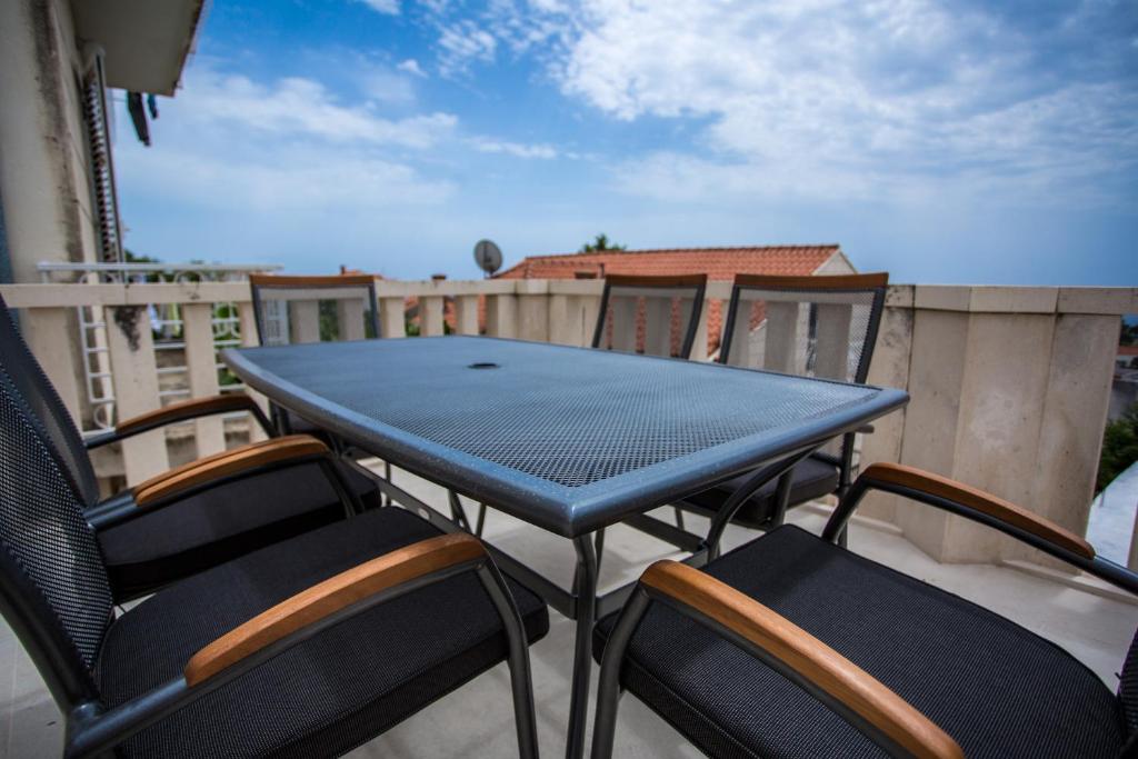 una mesa azul y sillas en el balcón en Serious Job Room, en Dubrovnik