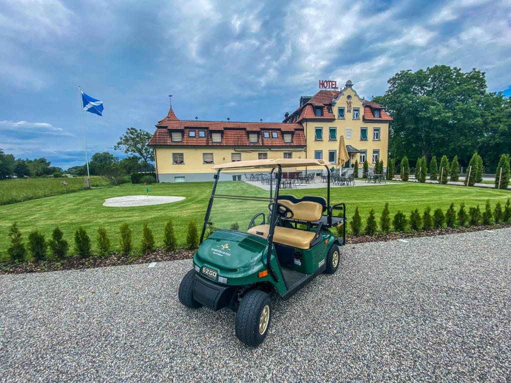 wózek golfowy zaparkowany przed domem w obiekcie Trompeterschlössle Hotel & Residence w mieście Tägerwilen