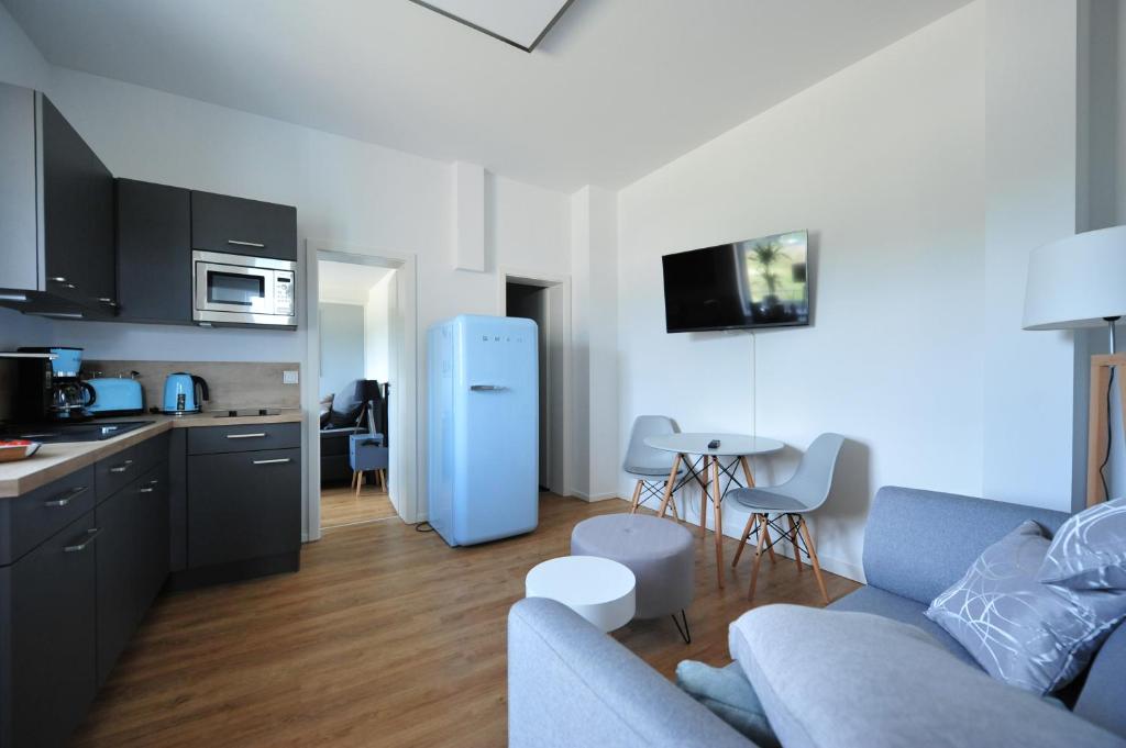 a kitchen and a living room with a blue refrigerator at Appartm. Schwarzen Pfuhl in Willich