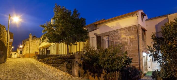 uma rua de calçada ao lado de um edifício à noite em Casa dos Navegantes em Belmonte