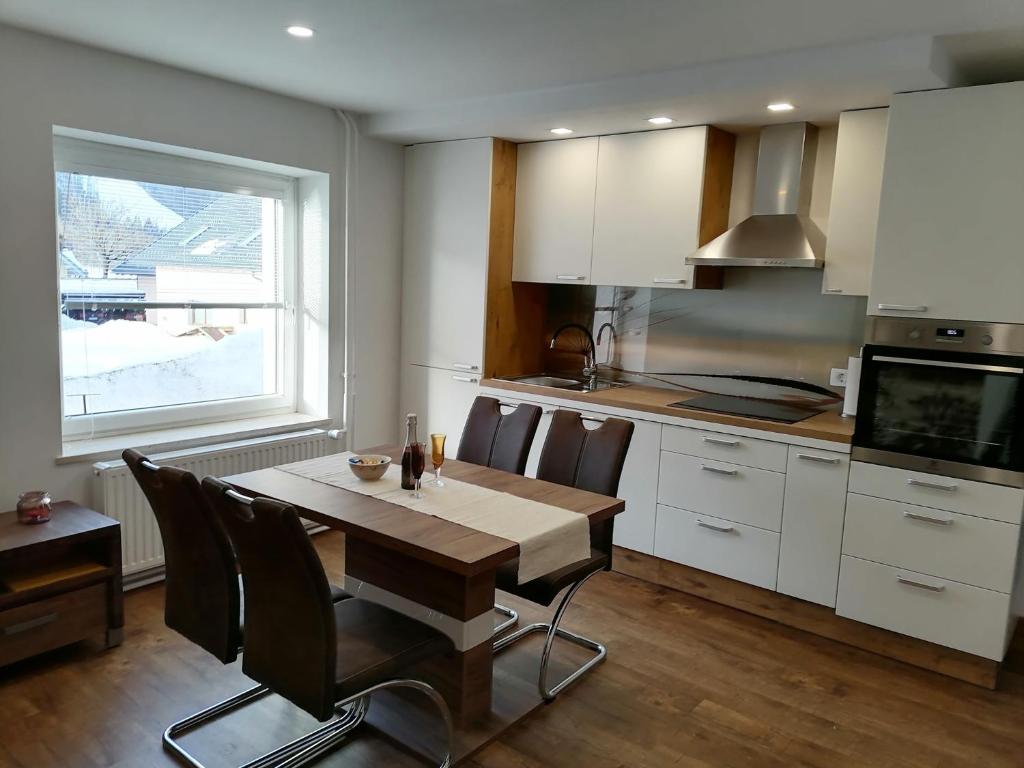 cocina con mesa de madera y ventana grande en Žbogar, en Rateče