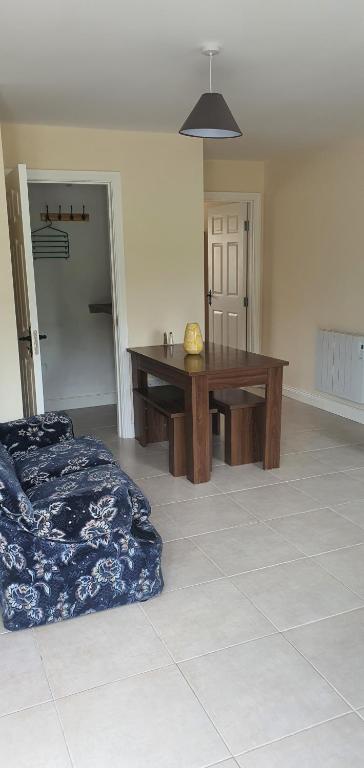 a living room with a wooden table and a bed at Hydeaway 2 in Donegal
