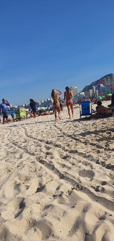 eine Gruppe von Menschen, die am Strand spazieren in der Unterkunft Apartabeach in Rio de Janeiro