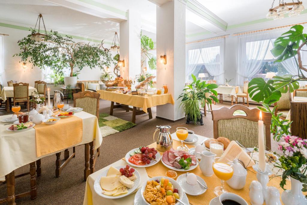 un comedor con mesas con comida. en Pension Schmidt, en Schierke