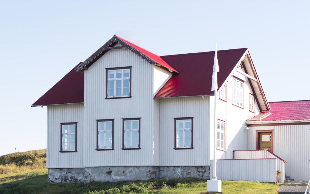 a white house with a red roof at Sýsló Guesthouse in Stykkishólmur