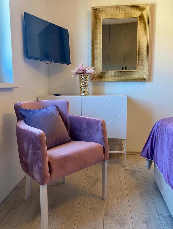 salon z fioletowym krzesłem i lustrem w obiekcie Golden Sunset 2 w mieście Nijvice