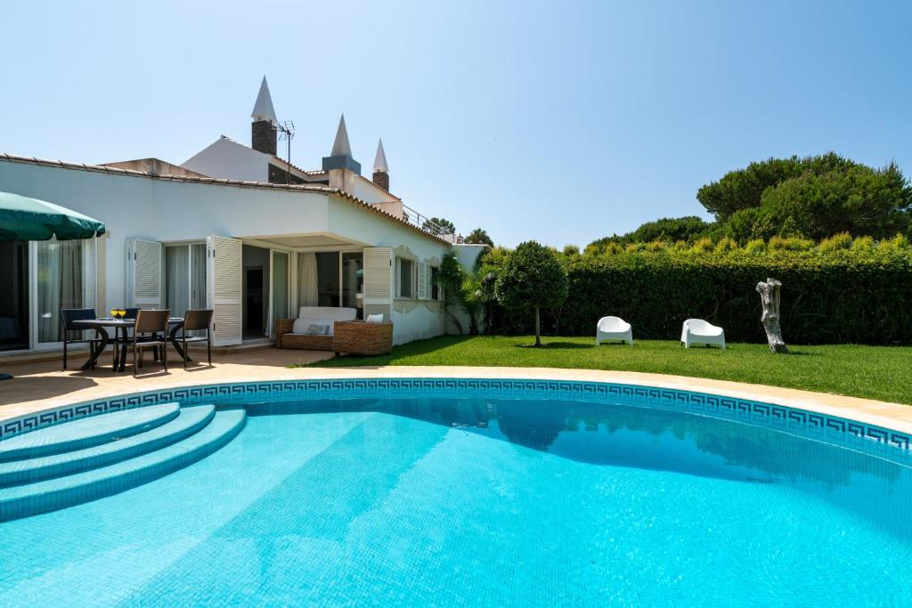 una piscina frente a una casa en Villa Macuti by SAPvillas, en Vilamoura