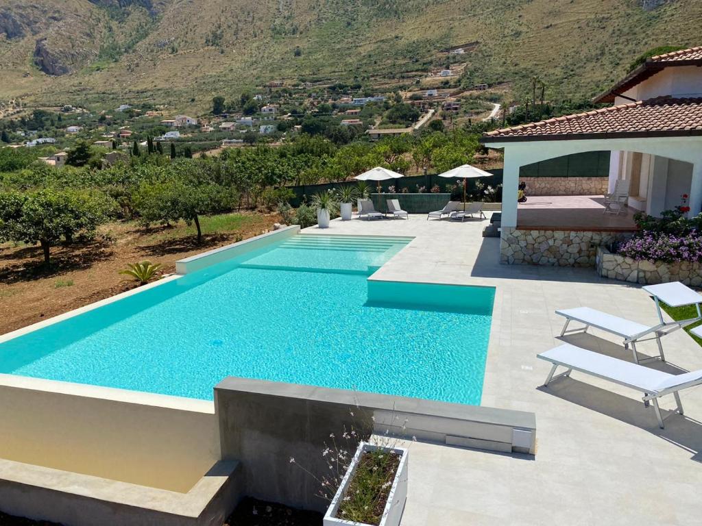 a swimming pool in front of a house at Villa Cycas Costamante in Castellammare del Golfo