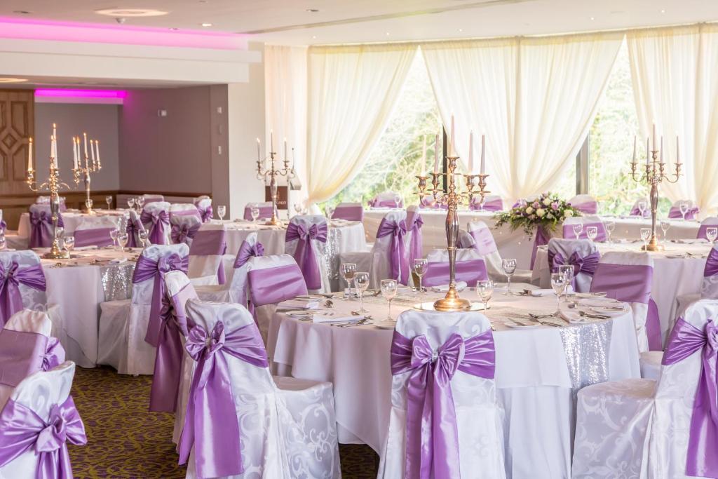 a room filled with tables with purple and white chairs at Ballygally Castle in Larne