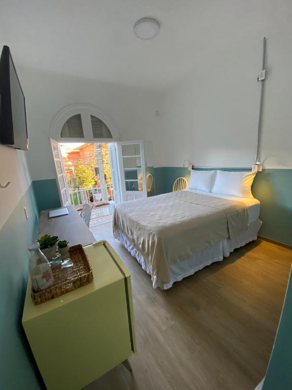 ein Schlafzimmer mit einem großen Bett und einem Tisch mit einem sidx sidx in der Unterkunft Angatu Hostel in São Paulo