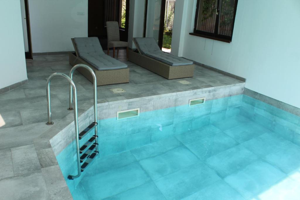 a swimming pool with two chairs at Villa Čengić in Sarajevo