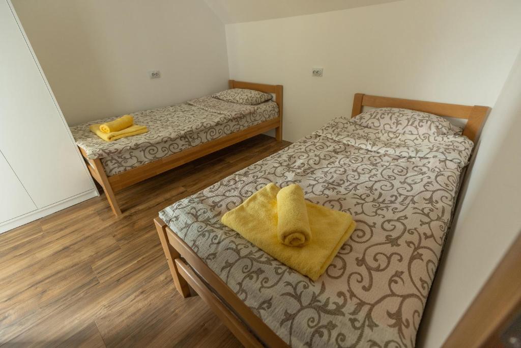 a room with two beds and a yellow towel on the bed at Zeleno srce in Soko Banja