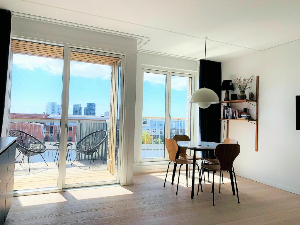 a living room with a table and chairs and a balcony at ApartmentInCopenhagen Apartment 1453 in Copenhagen