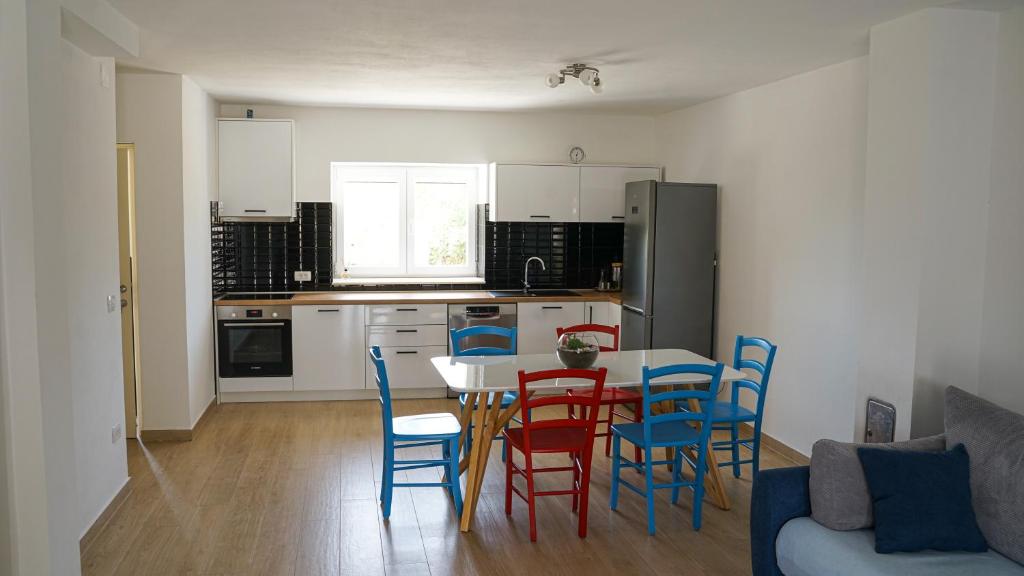 a kitchen and dining room with a table and chairs at Apartment Aria in Verunić