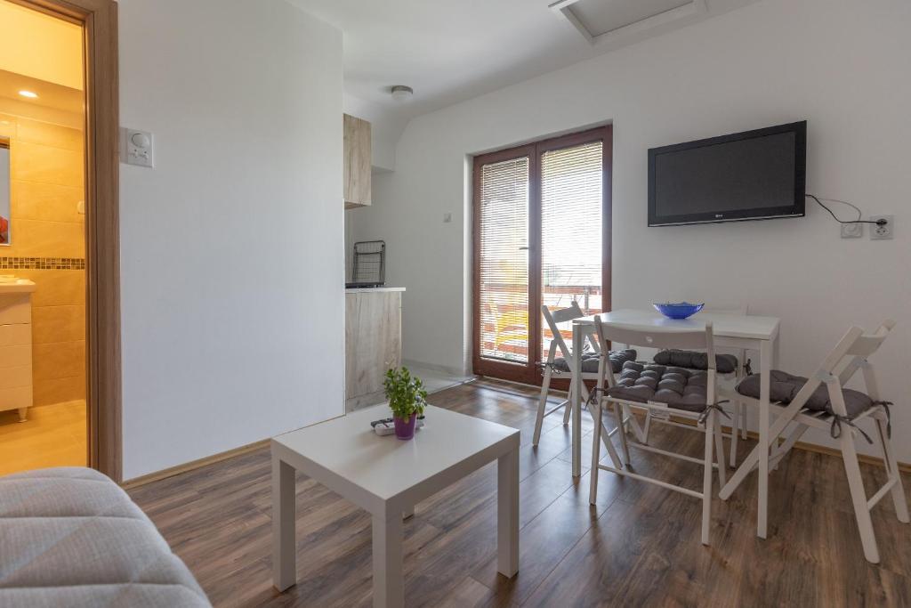 a living room with a table and a tv on the wall at Zeleno srce in Soko Banja