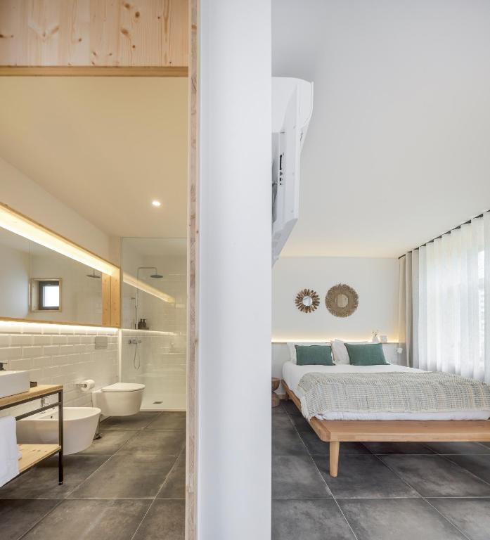 a bedroom with a bed and a bathroom at Ericeira Prime Villas in Ericeira