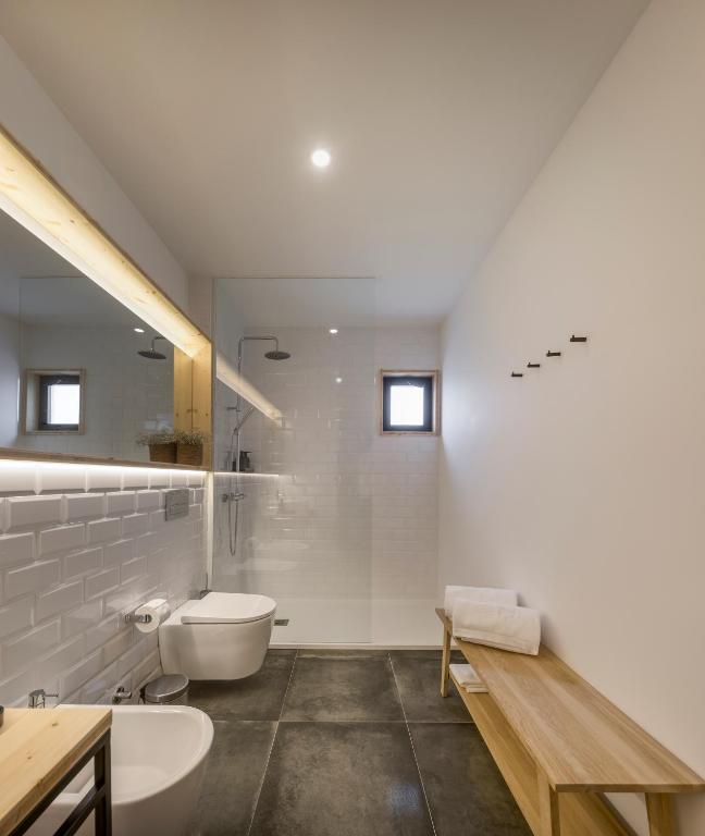 a white bathroom with a toilet and a sink at Ericeira Prime Villas in Ericeira