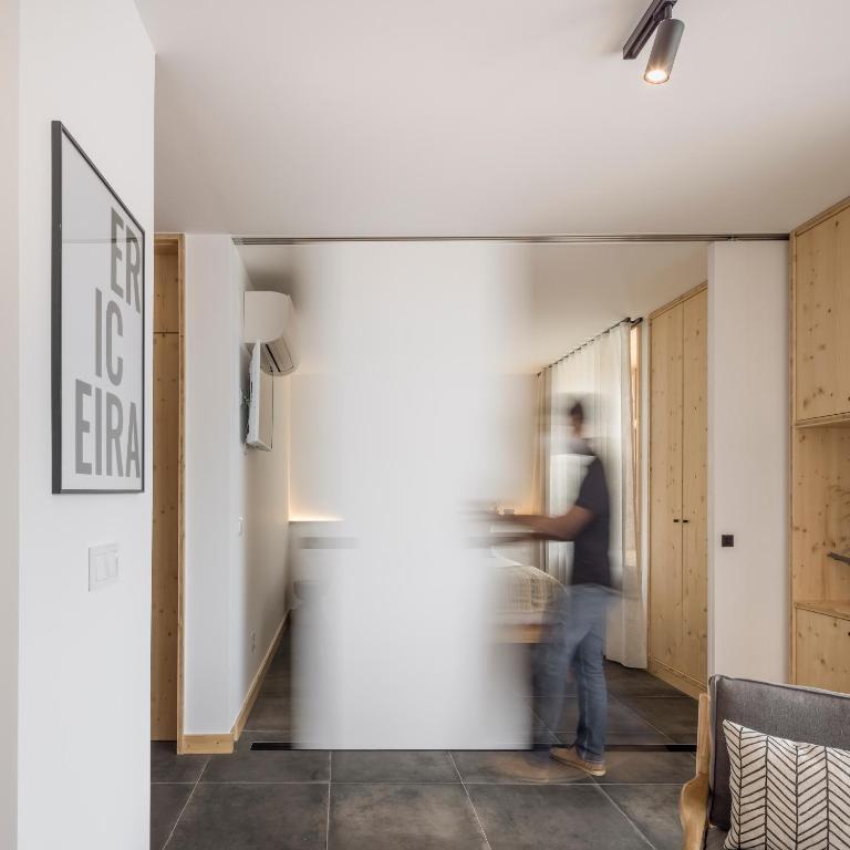 a man walking into a room with a hallway at Ericeira Prime Villas in Ericeira