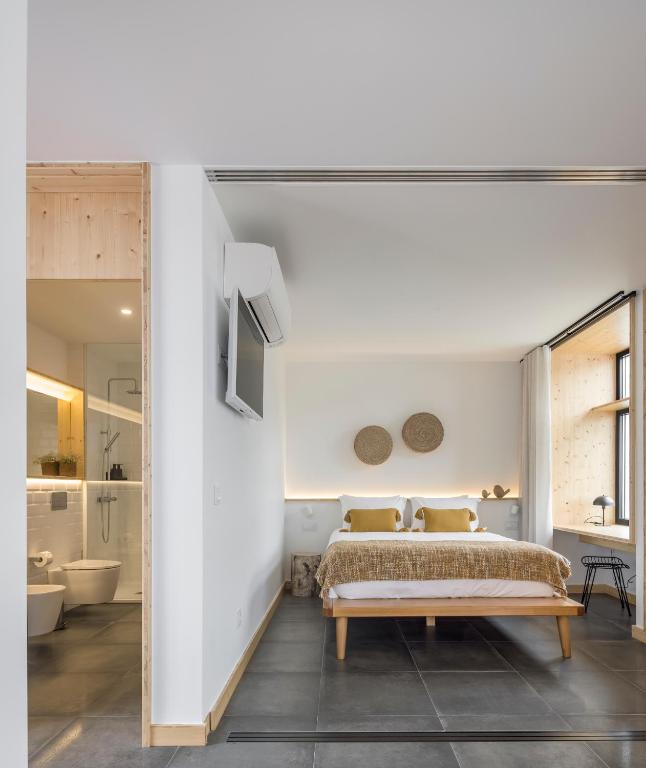 a bedroom with a bed and a bathroom at Ericeira Prime Villas in Ericeira