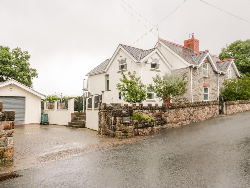 a house on a street with a stone wall at 2 Cae Mattw in Abergele