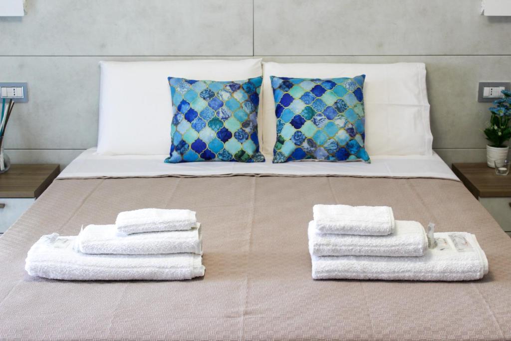 een bed met handdoeken en kussens erop bij Thalasso Rooms B&B in Cirella