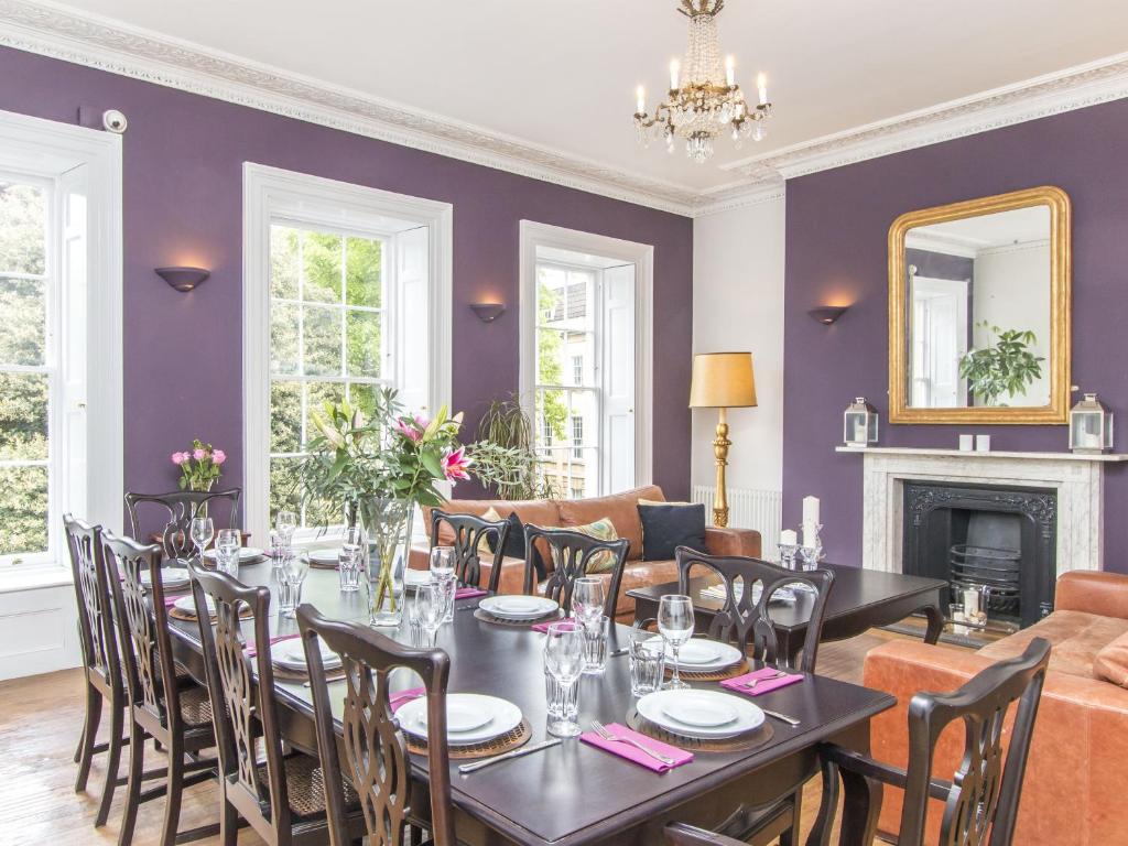 comedor con paredes de color púrpura, mesa y sillas en 3 Berkeley Square Guesthouse en Bristol