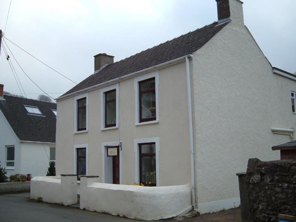 a white house with a window on a street at Morawel in Fishguard