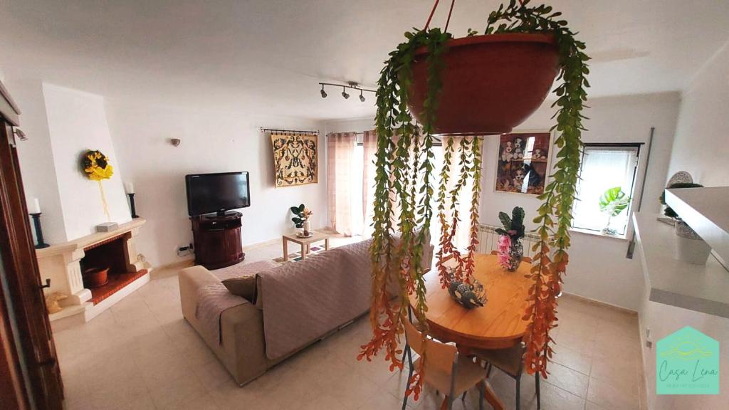 a living room with a couch and a table with plants at Casa Lena - Sítio da Nazaré in Nazaré