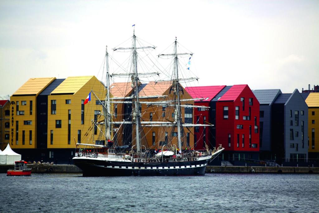 een grote boot in het water voor gebouwen bij All Suites Appart Hôtel Dunkerque in Duinkerke