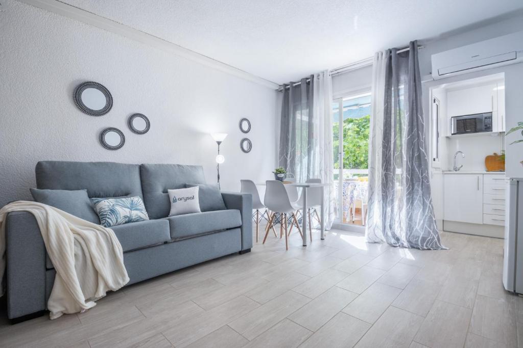 a living room with a blue couch and a table at Bonito estudio renovado in Salou