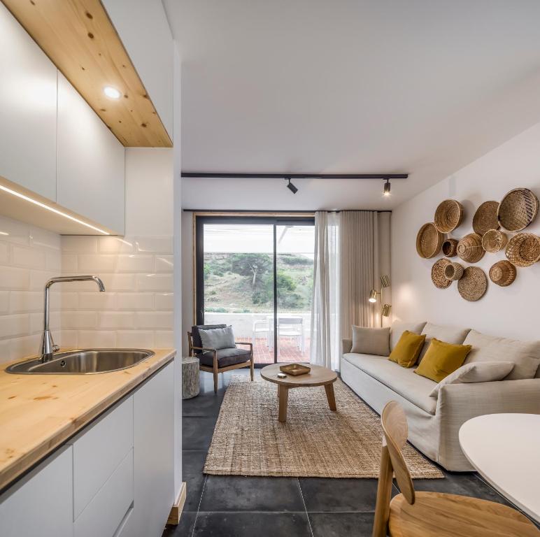 a kitchen and living room with a couch and a table at Ericeira Prime Villas in Ericeira