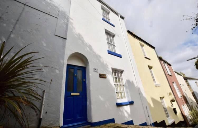 a blue door on the side of a white building at Saltys Cottage, Brixham - 2 min walk to the harbour in Brixham