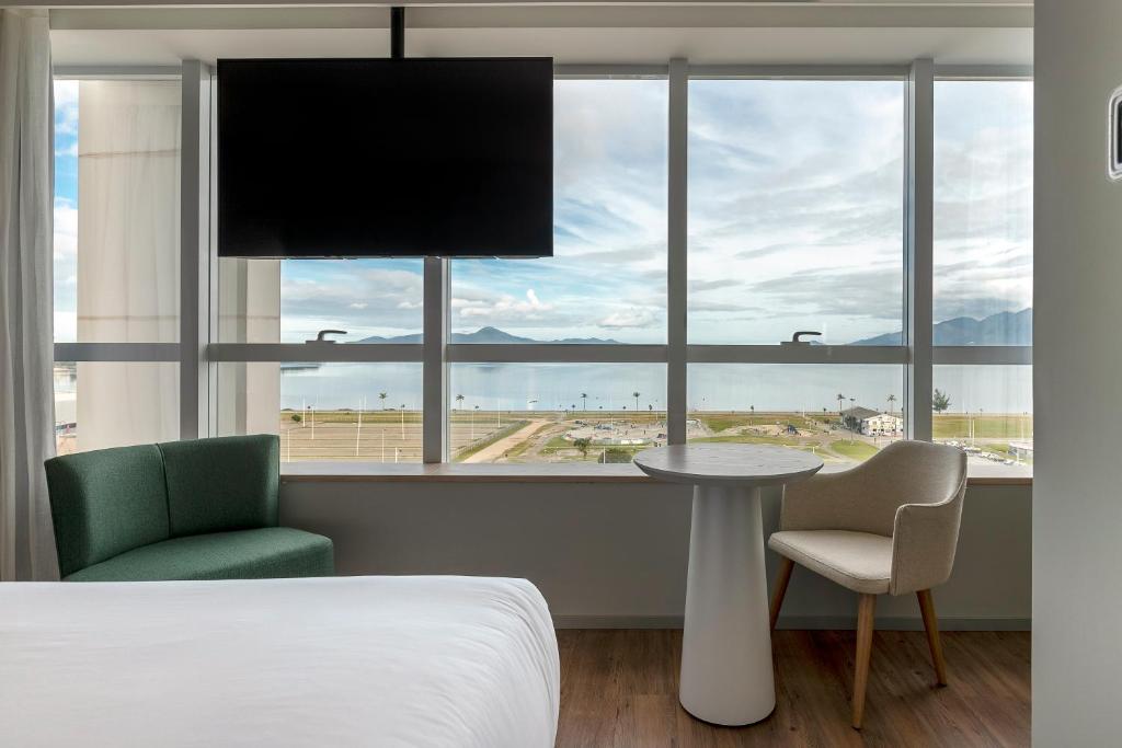 a bedroom with a bed and a table and a window at K-Platz Hotel in São José