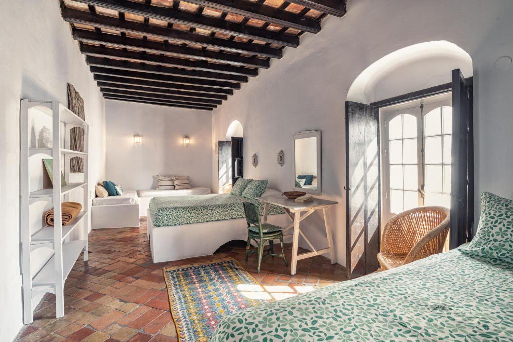 - une chambre avec 2 lits et une table dans l'établissement Eole Tarifa Rooms, à Tarifa