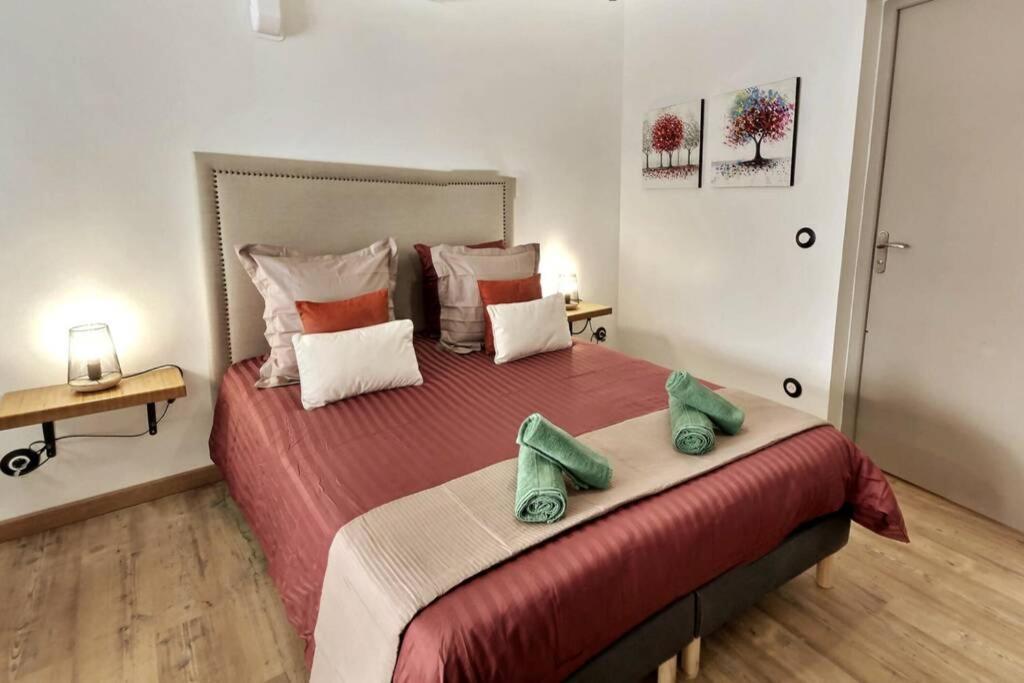 een slaapkamer met een groot bed met twee groene handdoeken erop bij Studio tout confort, terrasse, calme Moustiers #7 in Moustiers-Sainte-Marie