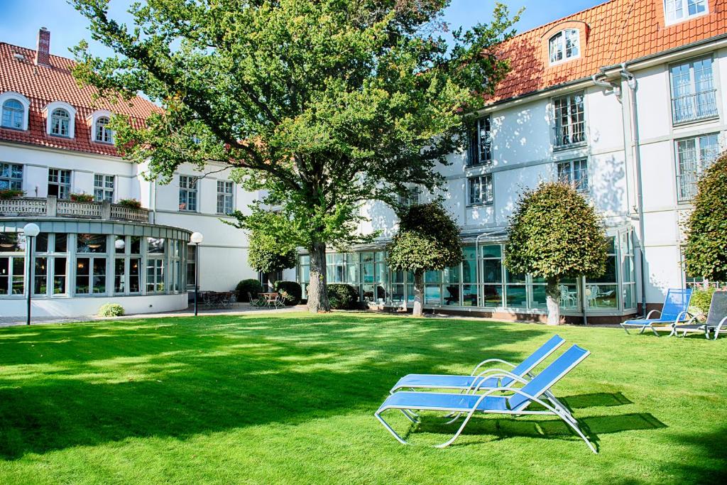 a blue chair sitting in the grass in front of a building at Hotel Villa Heine Wellness & Spa in Halberstadt