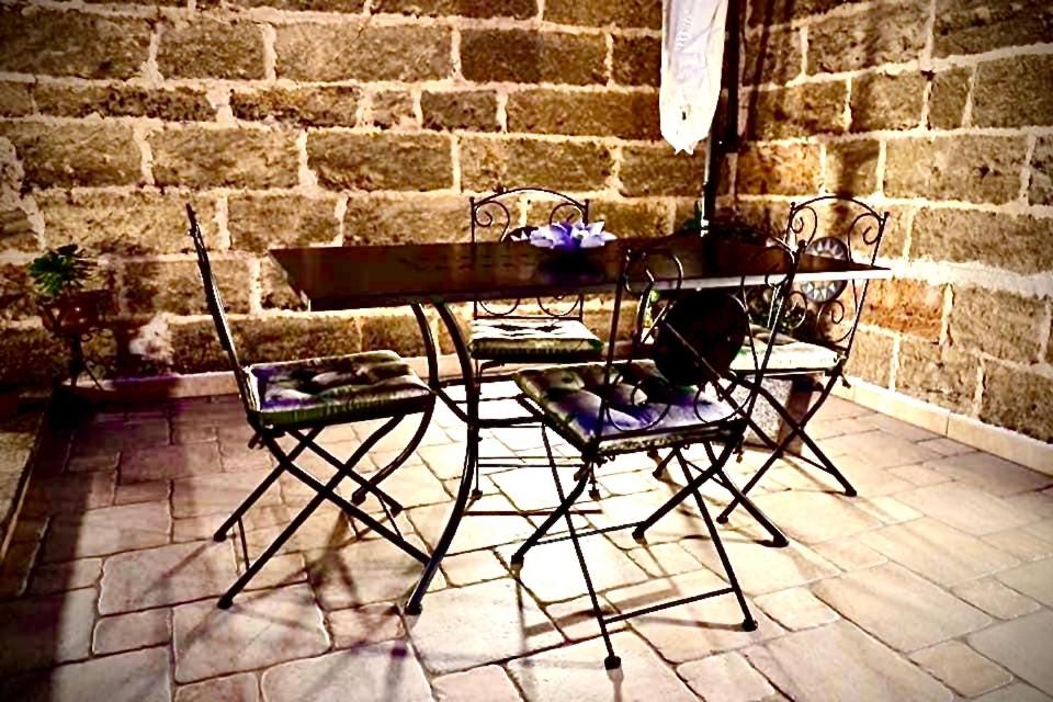 a table and two chairs and a brick wall at Dimora luxury Santa Lucia Apartaments in Galatone