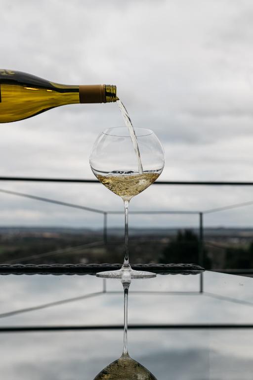 a glass of white wine being poured from a bottle at Bellevue appartementen in Simpelveld