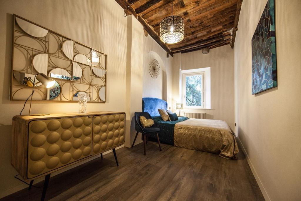 um quarto com uma cama e uma cadeira em Historic Center Luxury Apartment em Lucca