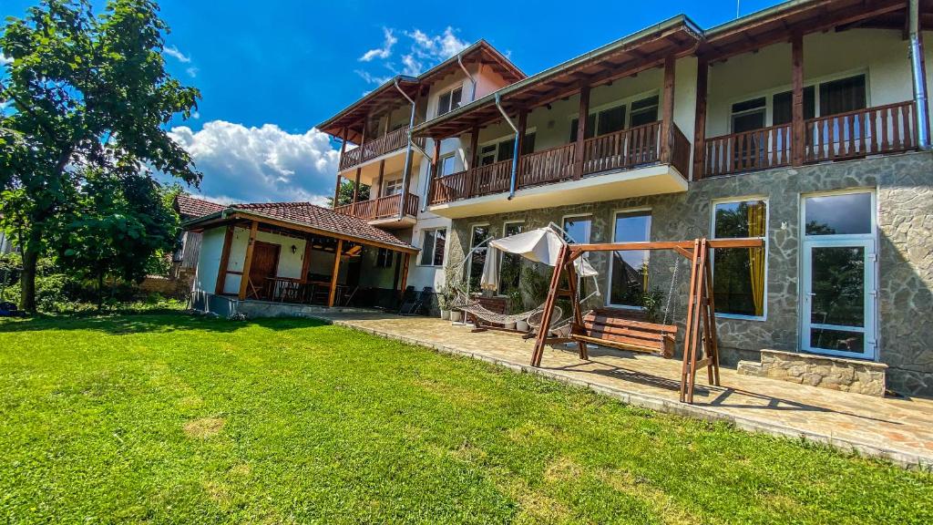 uma casa com um relvado em frente em Guest House Au Nature em Golyama Zhelyazna