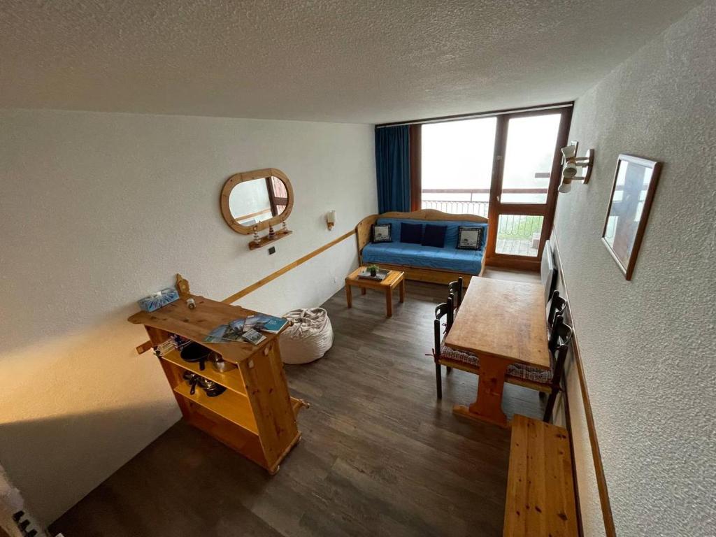 ein Wohnzimmer mit einem Tisch und einem Spiegel in der Unterkunft Le choucas - Les Arcs in Arc 2000