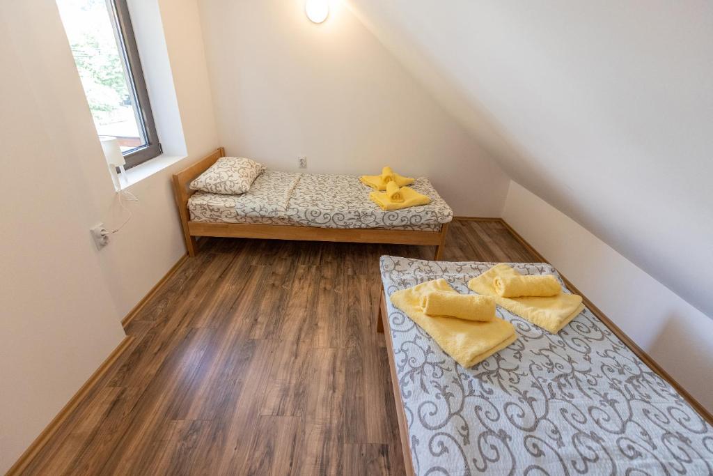 two beds in a small room with wooden floors at Zeleno srce in Soko Banja